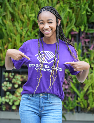 Ahsha B., in Military purple Boys & Girls Club t-shirt pointing at herself