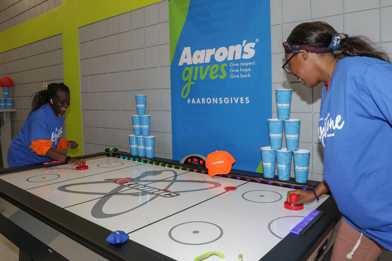 Aaron's renovation: Club teens playing air hockey