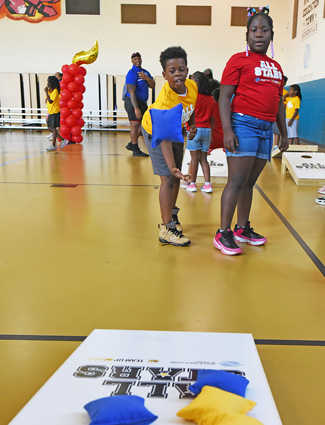 Club kids playing cornhole