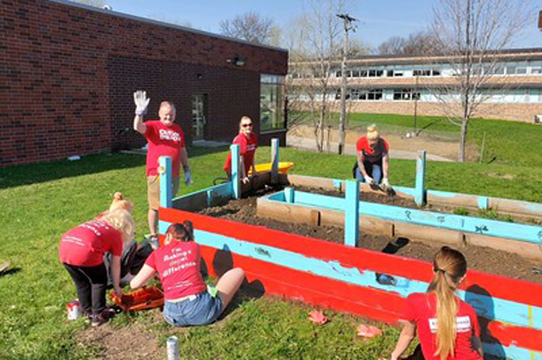Clubs Get a Refresh - Group outside cleaning up planter