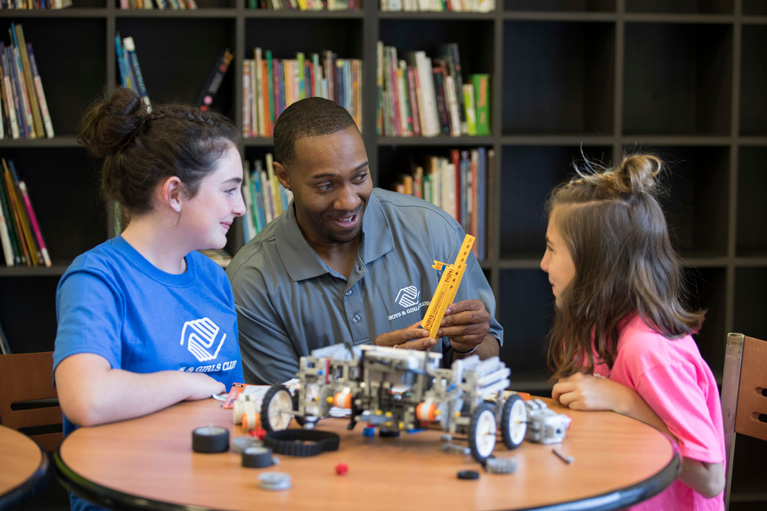 Youth Development Professional and 2 Club kids working on a STEM project