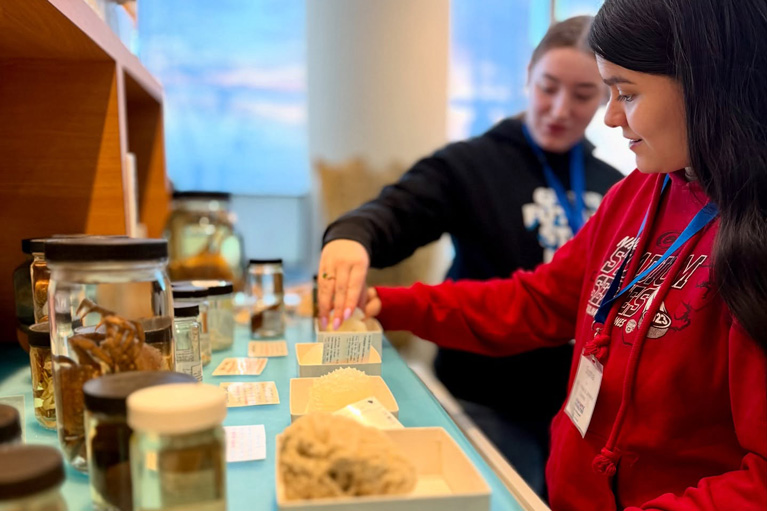 Girl with Volunteer looking at samples