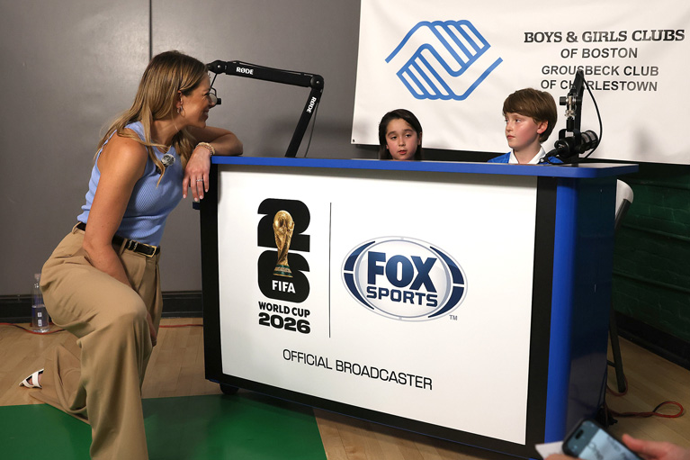 Club kids sitting behind FOX Sports desk
